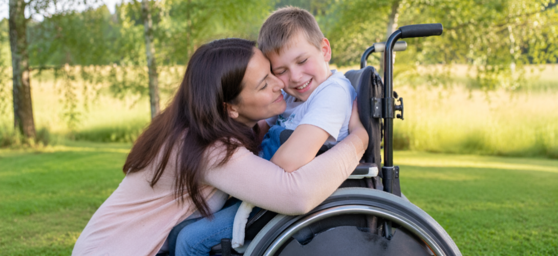 Eine Mutter umarmt ihr Kind im Rollstuhl